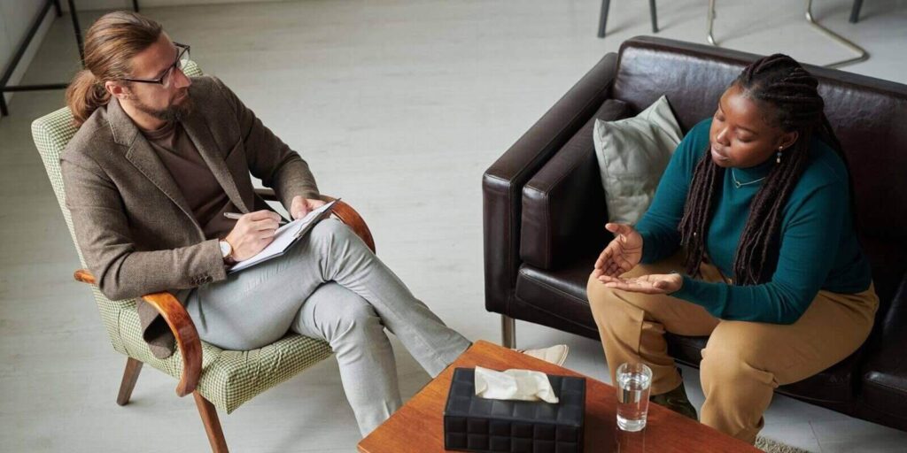 psychotherapist discussing problems with patient during individual therapy session at office