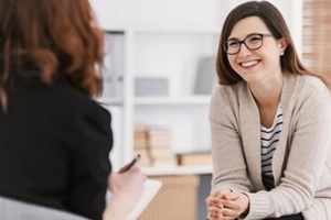 happy woman during successful individual therapy with counselor at clinic