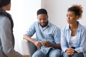 frustrated afro woman complaining marital counselor about husband indifference In office