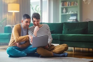 handsome gay couple using laptop computer