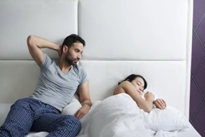 man trying sexual approach with woman in home bed