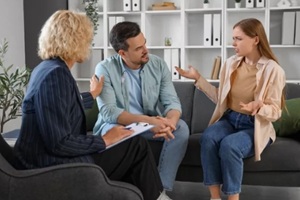 displeased young couple visiting psychologist in office