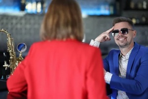 smiling confident man in sunglasses meets woman near bar counter