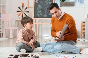 speech therapist working with little boy in office