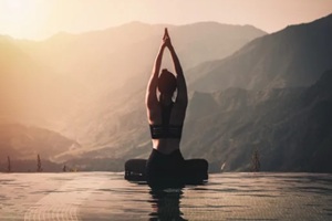 woman practice yoga Lotus pose on the pool above the mountain peak