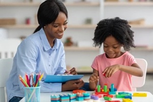 female psychotherapist working with little kid at office