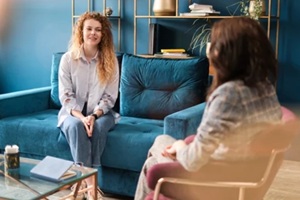 happy red-haired woman talking to a female psychologist