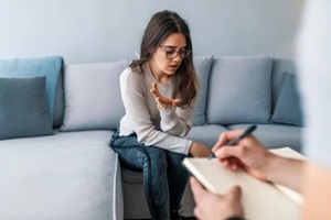 psychologist listening to woman in trouble during therapy session