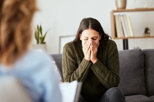 stress, psychologist and talking to woman patient on sofa for medical support, depression risk and trauma