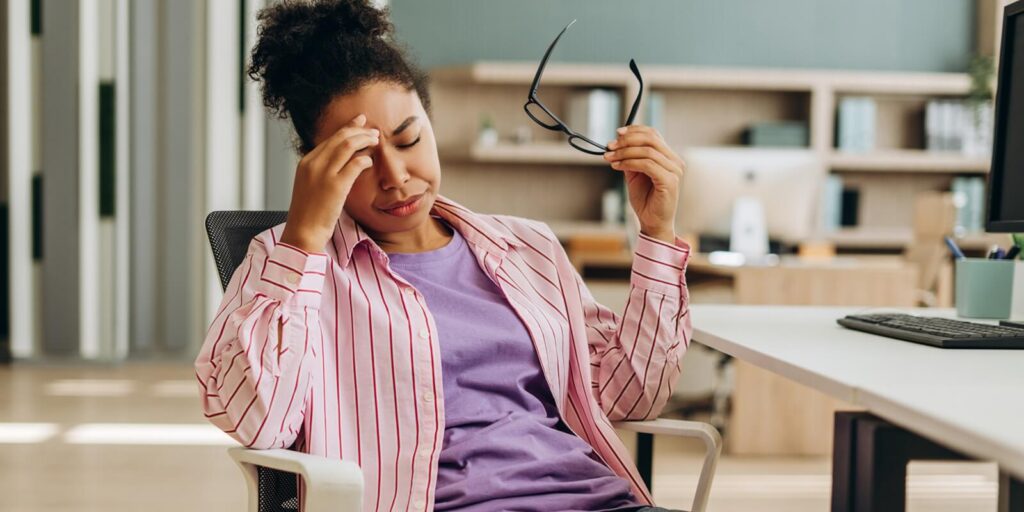 tired office manager suffering from headache at workplace