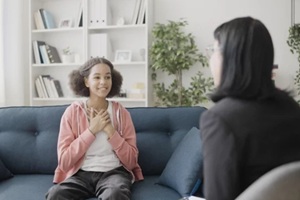 psychologist talking to happy teenager, adolescent counseling service