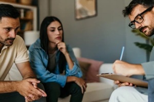 psychologist taking notes during couples therapy session