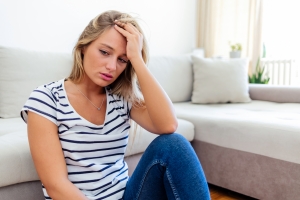 Woman Sitting Near Sofa Struggling with Poor Mental Health