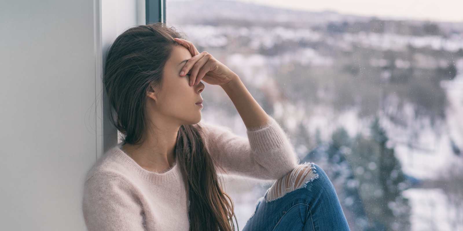 Maryland Woman Suffering from Winter Depression Sitting Near Window