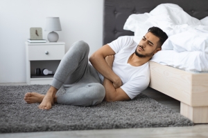 Young Man Sitting on the Floor of His Bedroom Suffering from Seasonal Depression
