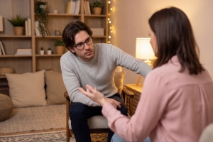 Male Psychologist Listening to Female Patient During Therapy Session
