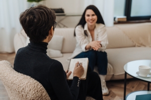 Woman Smiling While Talking with Therapist in Session