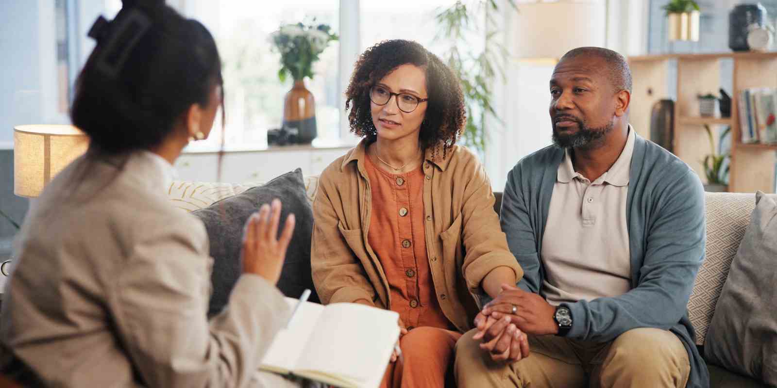 Couple Holding Hands with Discussion on Sofa During Therapy