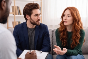 Young Couple Talking to a Counselor During a Therapy Session