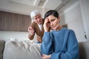 Distressed Mature Woman Hiding from Yelling Man Showing Caregiver Resentment